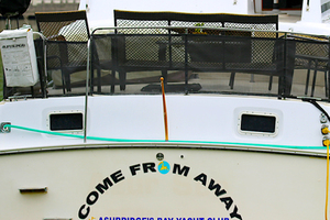 a  boat painted Come From Away in the musical’s typeface and the “O” resembles the show’s graphic logo of a globe