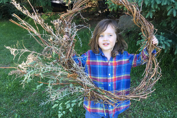 Boy holding and looking through a large wreath